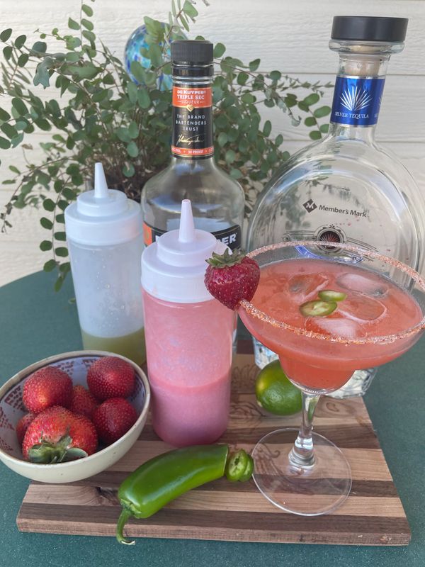Spicey strawberry margarita with jalapeño simple syrup & fresh strawberry purée with a Tajin rim. 