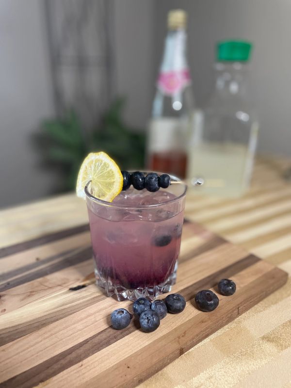 Blueberry smash mocktail made with blueberries, simple syrup, and topped with N/A sparkling rosé. 