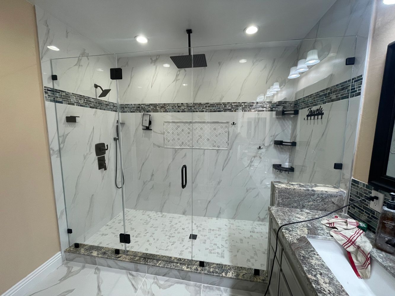 Modern bathroom with glass shower enclosure and marble accents.