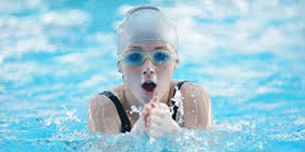 Swimmer in goggles and cap swimming.