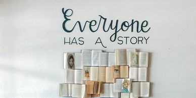 a brown leather couch sitting in front of a white wall "Everyone has a story"