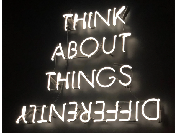 Neon sign: "Think about things differently" diff upside down & backwards by Ivan Bertolazzi | Pexels