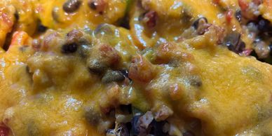 beans and rice covered with cheese in a bell pepper.