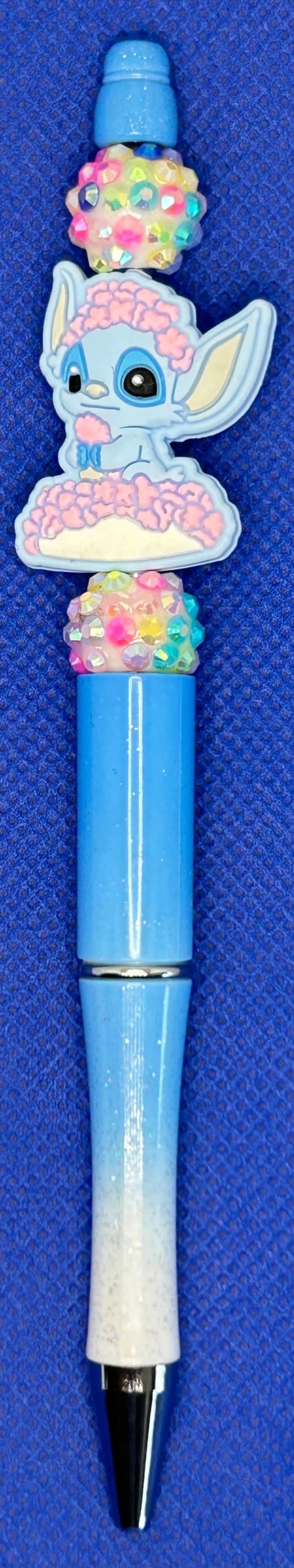 Blue pen with a cute cartoon character and colorful gems.