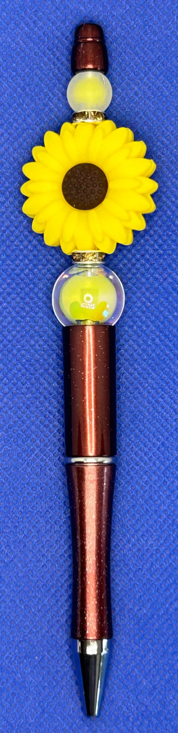 Decorative brown pen with a bright sunflower design.