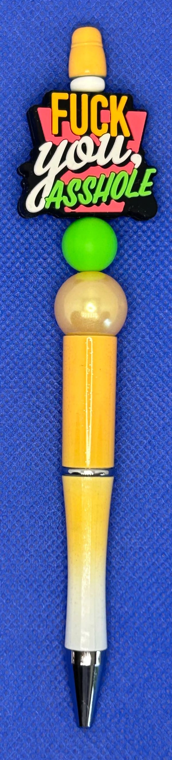 Colorful pen with offensive text on top.