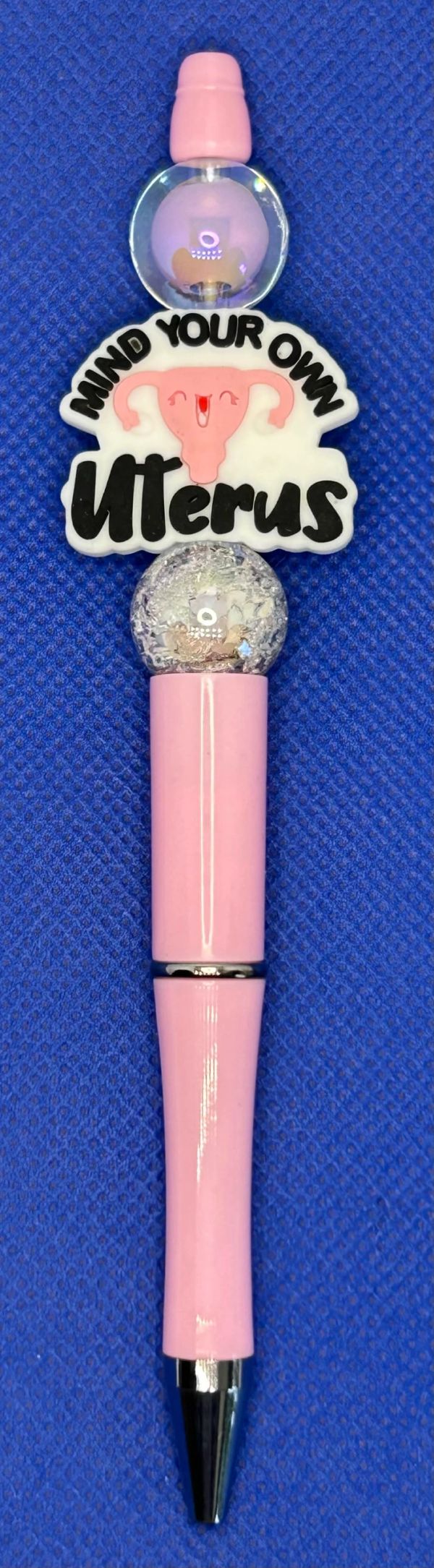 Pink pen with "Mind Your Own Uterus" message.