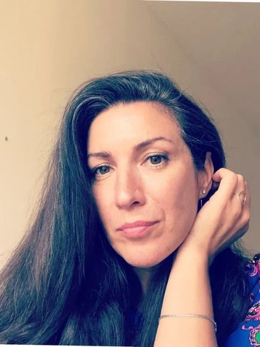 Portrait of a woman with long dark hair and a thoughtful expression.