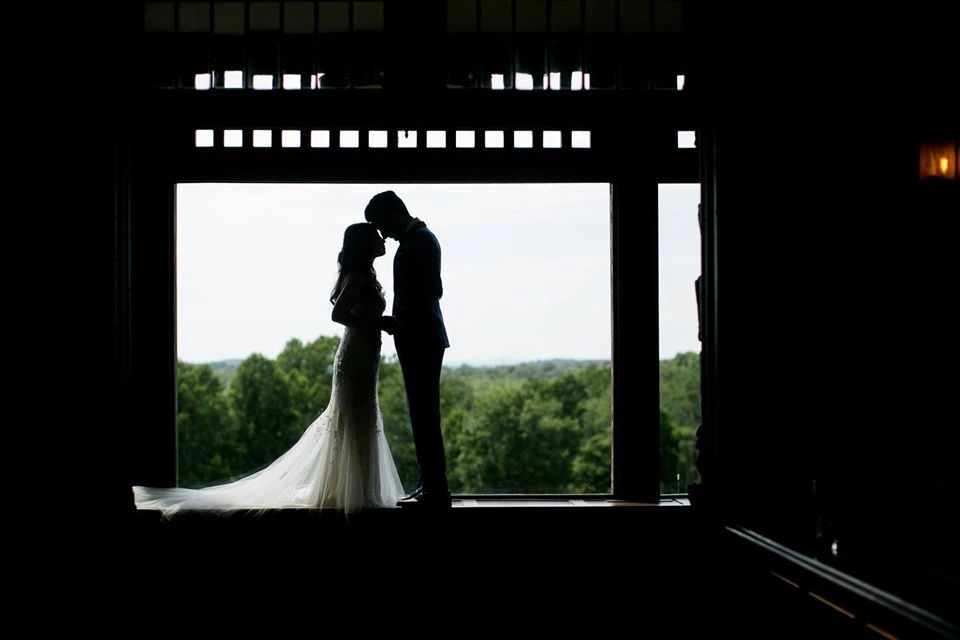 Silhouette of a couple in wedding attire sharing a tender moment.