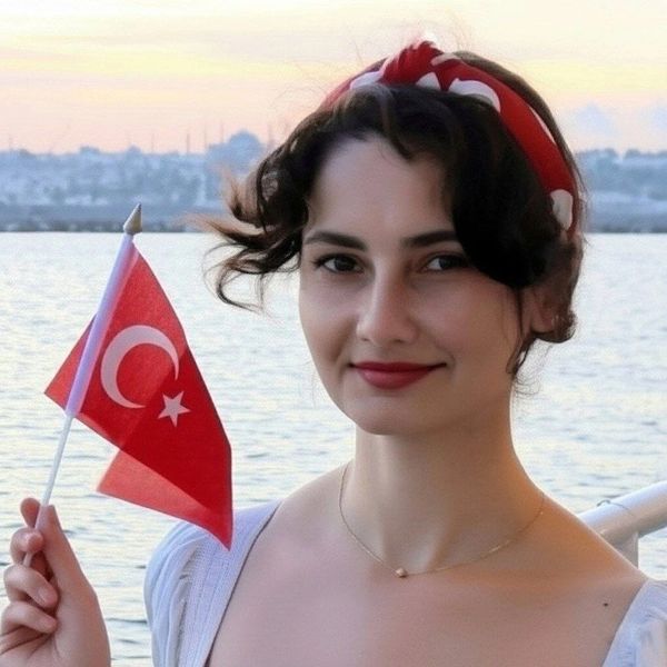 Young woman holding a Turkish flag by the water at sunset.