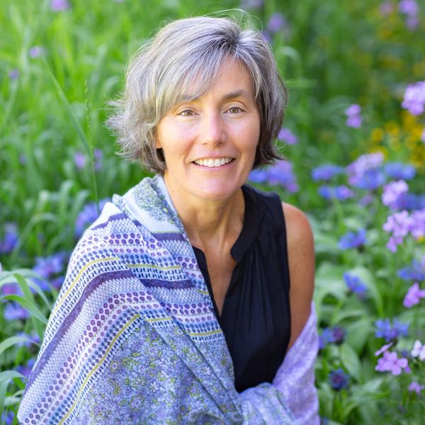 Amy Layne Litzelman sitting in flowers.