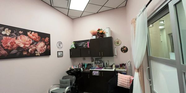 Cozy beauty salon corner with floral art and salon chairs.