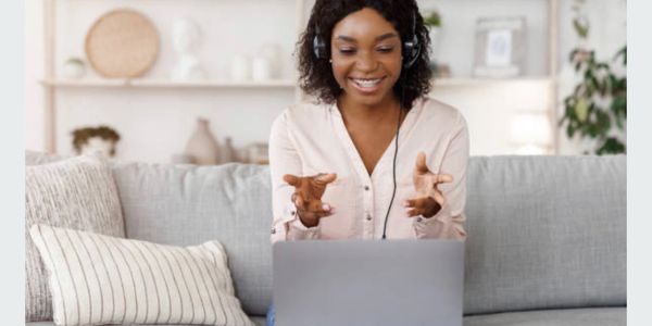 A joyful woman beams with excitement during her online life coaching session feeling empowered. 