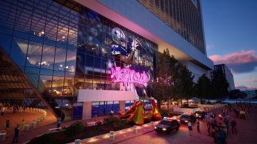 Neon lights illuminate a modern building entrance at dusk.
