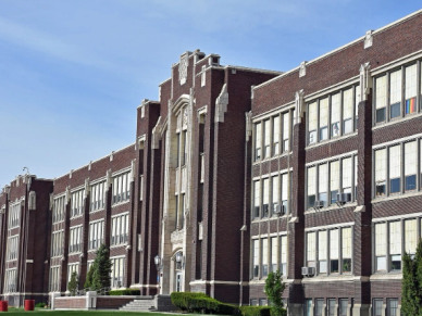 Large brick school building under a clear sky.