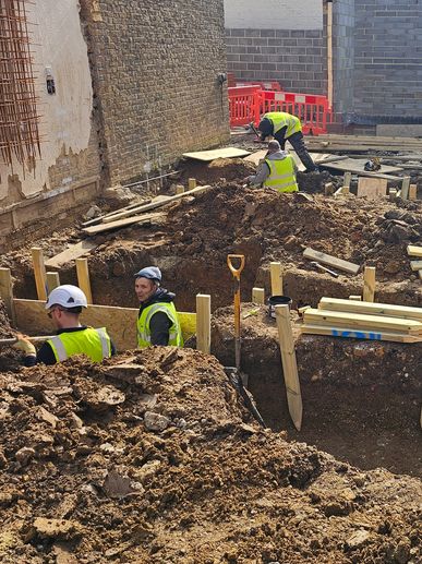 Construction workers digging foundation trenches.