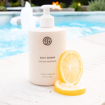 Body moisturizer bottle with lemon slices by a pool.