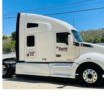 White Swift Limited Inc. semi truck parked outdoors under clear blue sky.