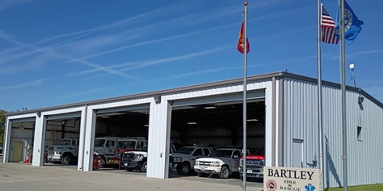 Fire station building with multiple rescue vehicles inside.