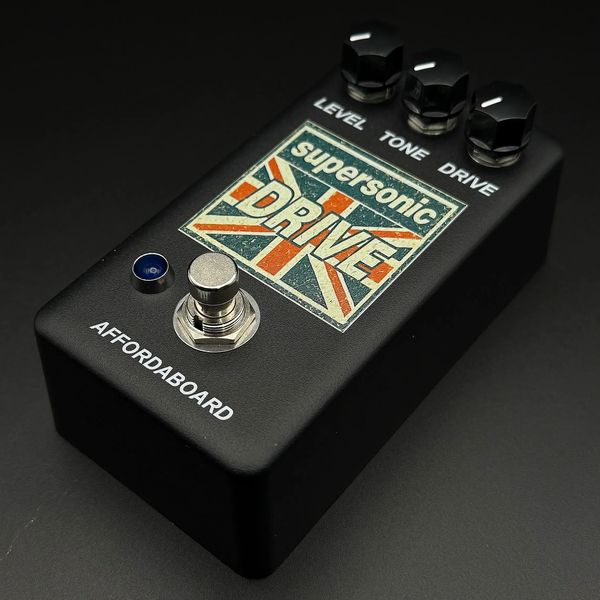 Black guitar effects pedal labeled 'supersonic DRIVE' with knobs for level, tone, and drive.