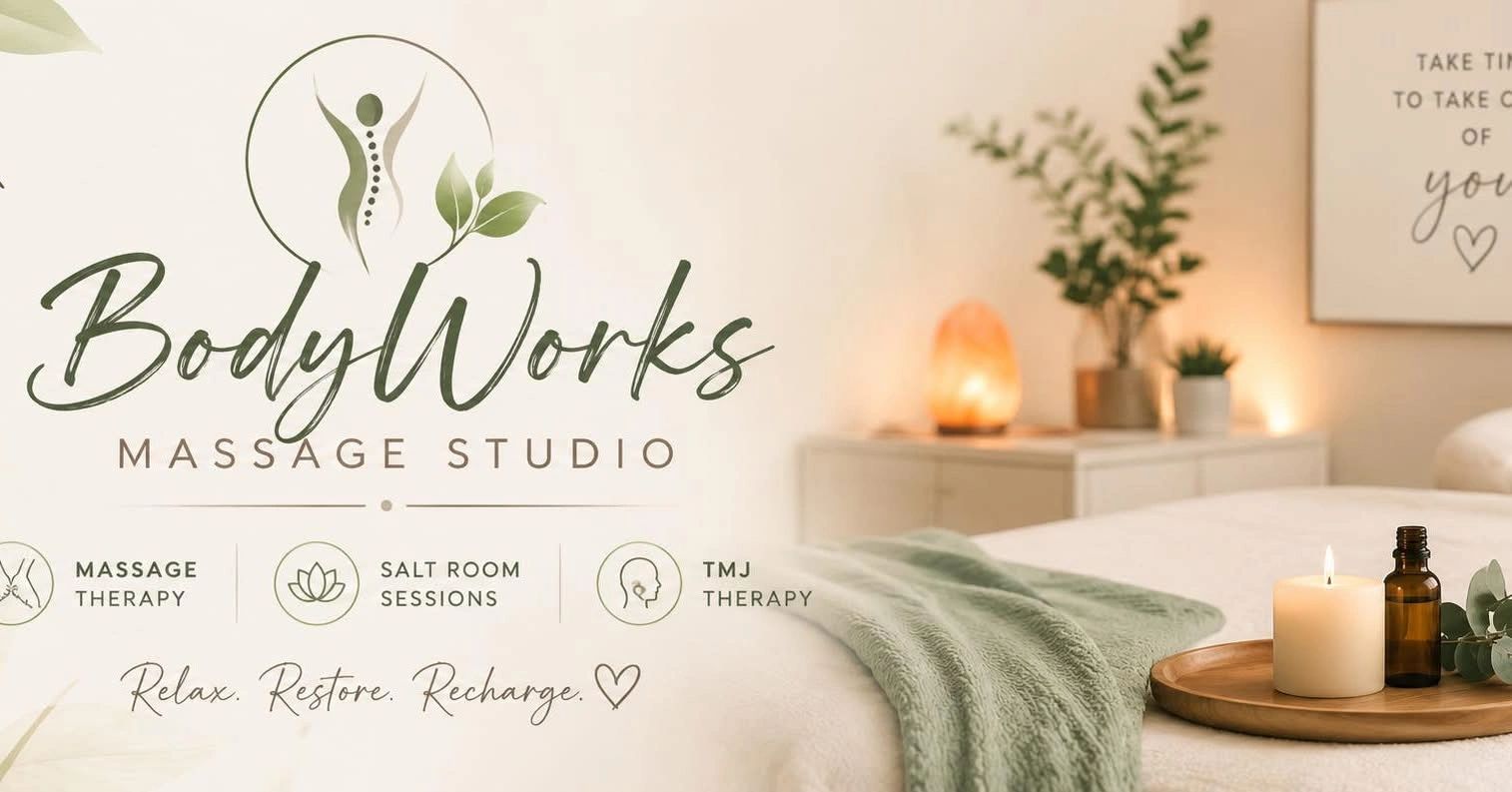 Tranquil massage studio with candle and oil on wooden tray.