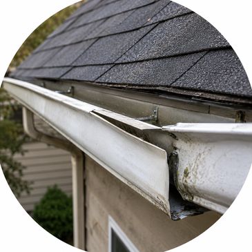 Damaged white gutter pulling away from the roofline and needing repair.