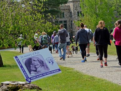 People and dogs walking in a memorial charity walk event.