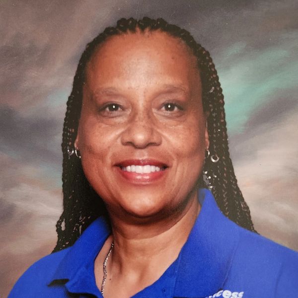 Woman with braided hair smiling in blue shirt