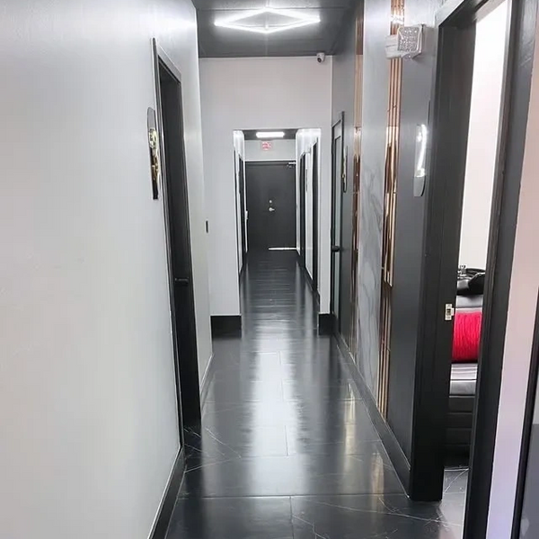 Sleek modern hallway with black doors and polished dark floor tiles.