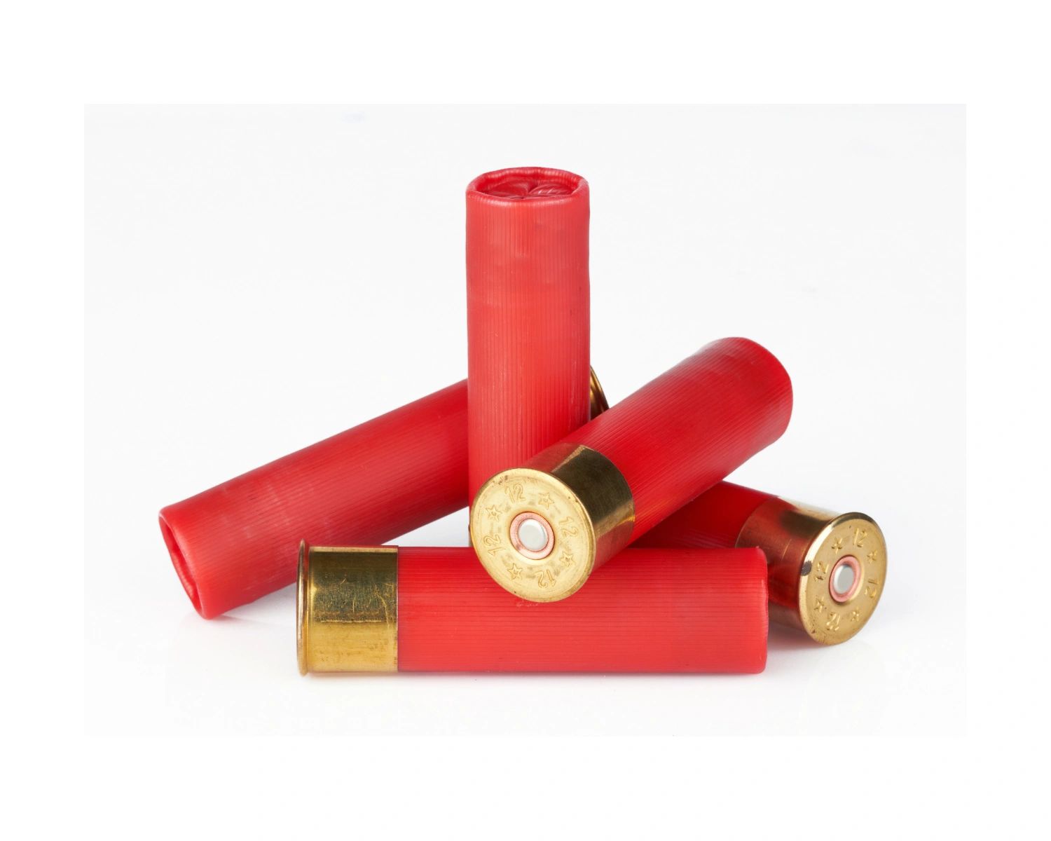 Five red 12-gauge shotgun shells arranged on a white surface.