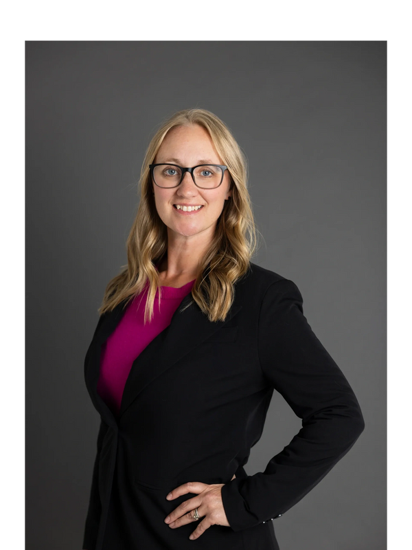 Dr. Jen Mimish, Women's Health Nurse Practitioner in a bright pink shirt with suit jacket, glassesm 