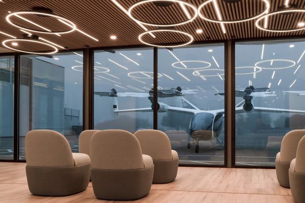 Modern interior with circular ceiling lights and airplane outside.