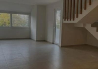 Habitación vacía con ventana y escalera.
