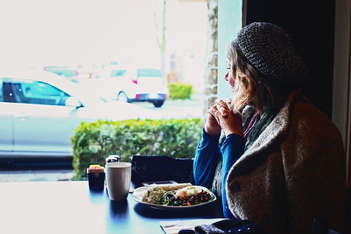 Customer eating breakfast and drinking espresso at Peace Arch City in Blaine, WA