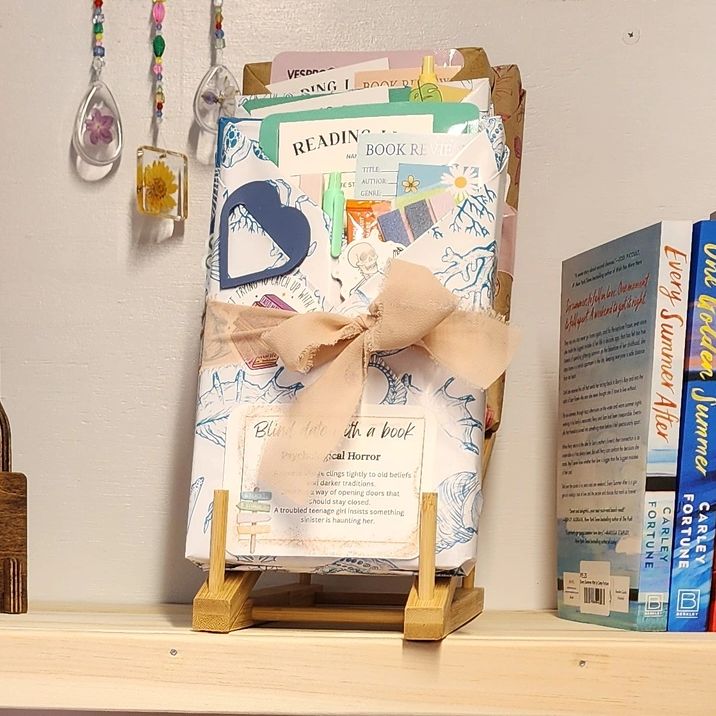 Decorative book with a ribbon and bookmarks on a wooden stand.