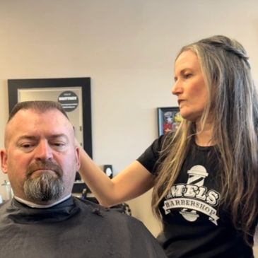 Mel, the owner of the shop cutting hair