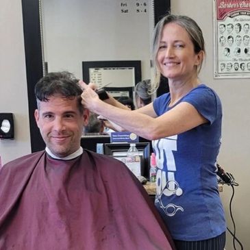 Picture of the owner Mel, of Mel's Barber Shop doing a clipper cut haircut