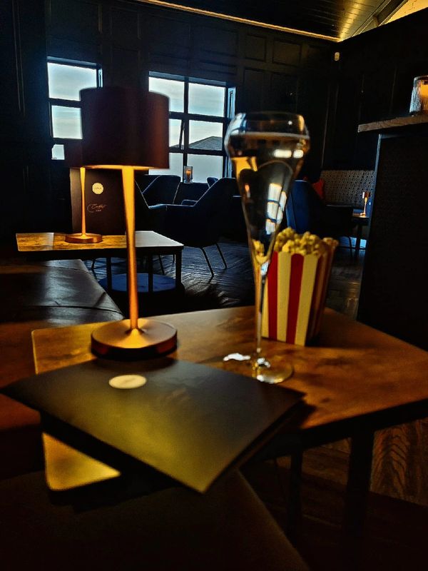 Cozy dimly-lit lounge with popcorn and champagne.