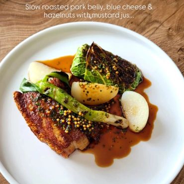Slow roasted pork belly with blue cheese, hazelnuts, and mustard jus.
