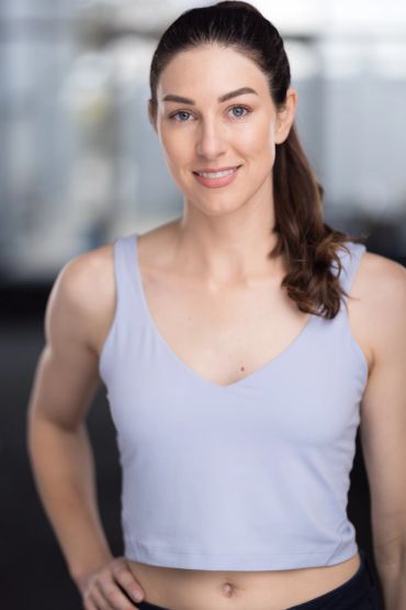 Woman in workout clothes smiling at the camera.