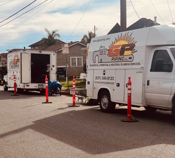 GP Piping service vans at work on a residential street.