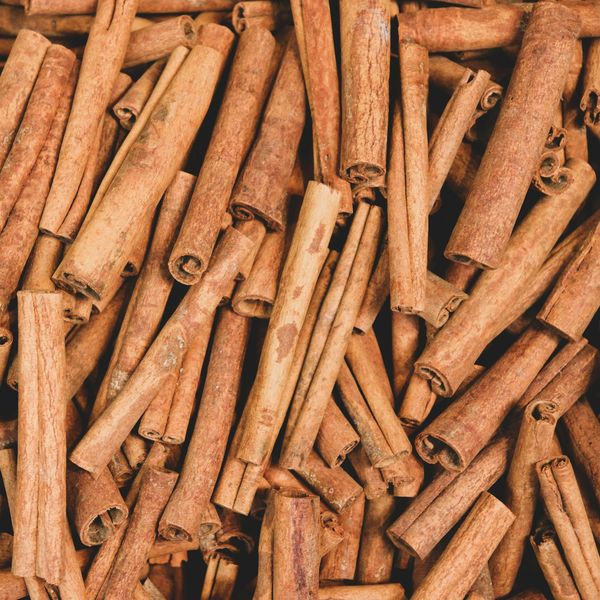 Close-up of numerous cinnamon sticks piled together.