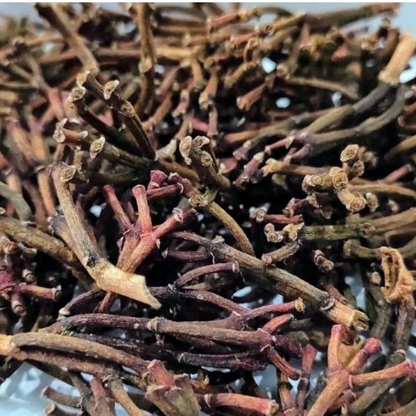 Close-up of dried clove stems piled together.