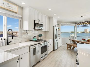 Bright modern kitchen with white cabinets and waterfront view.