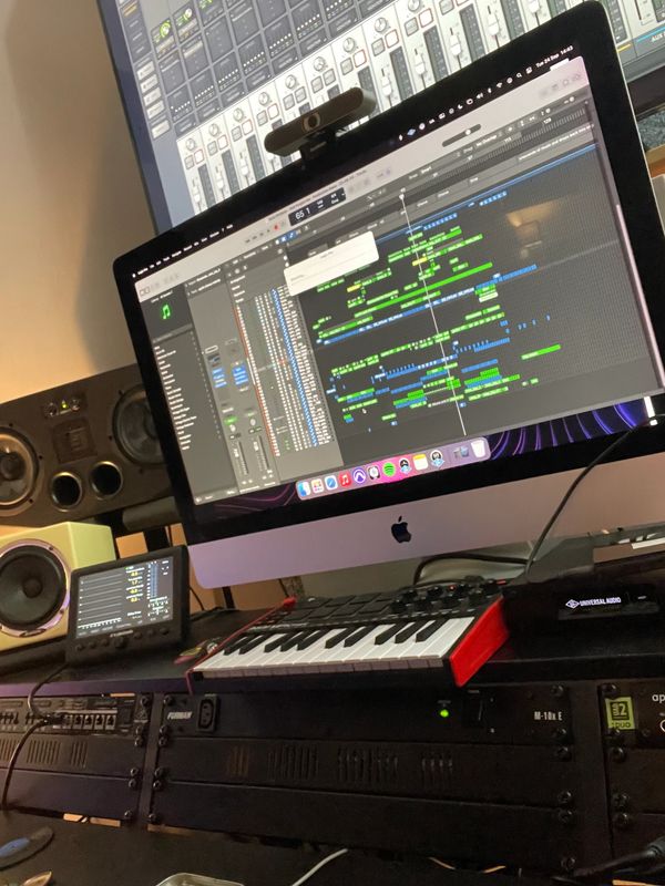 Music production setup with iMac, MIDI keyboard, and studio monitors - Production Room.