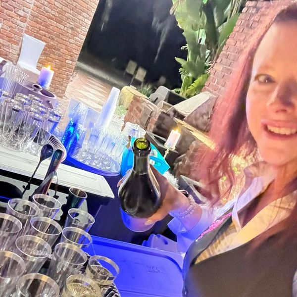 Bartender pouring champagne at wedding reception bar