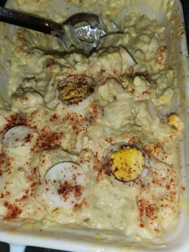 Creamy egg salad sprinkled with paprika in a serving dish.