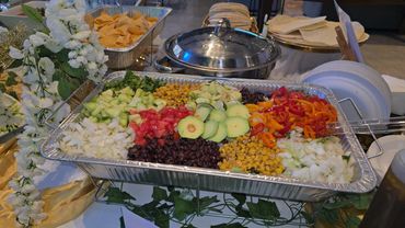 Colorful tray of fresh salsa ingredients with chips on the side.