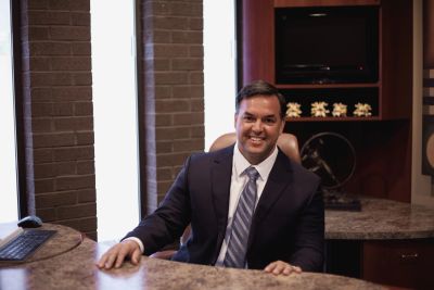 Smiling businessman sitting at office desk.