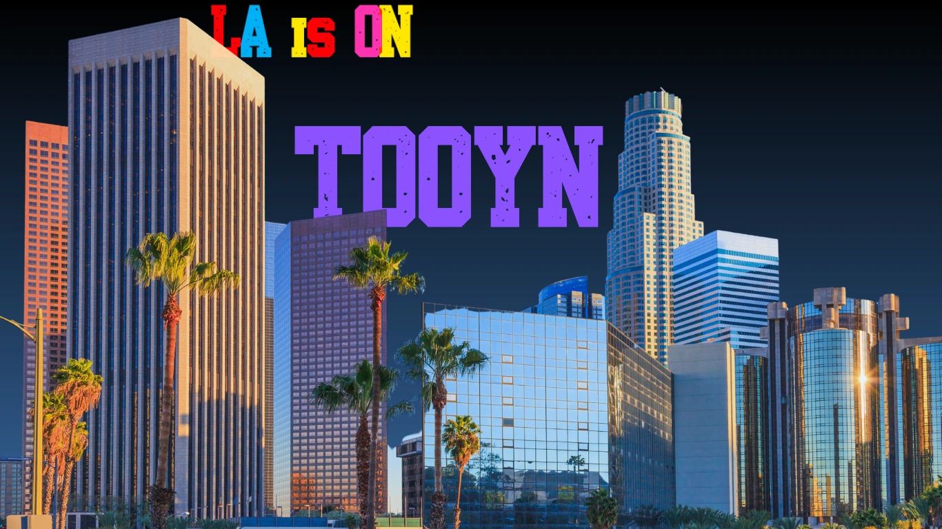 Colorful text over Los Angeles skyline at dusk.